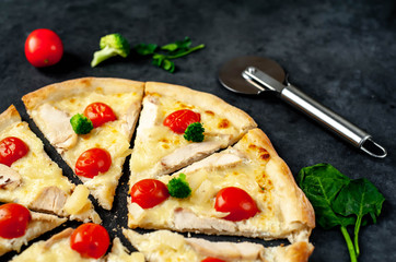 delicious pizza with pineapple, broccoli, tomatoes, mozzarella cheese, chicken fillet on a stone background with copy space for your text