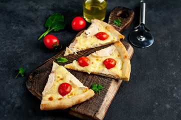slices of pizza with pineapple, tomatoes, mozzarella cheese, chicken fillet on a stone background