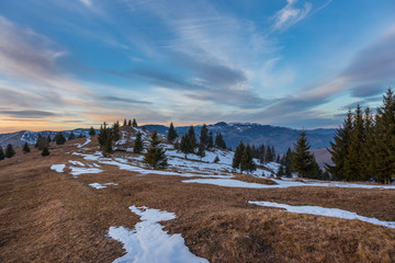 Sunset spring Carpathian mountains landscape with snow-covered ridge.