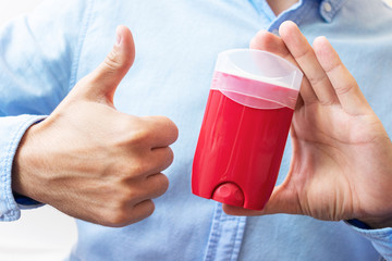 Man shows deodorant and sign super with fingers, man's hands, cropped image, close-up, copy space