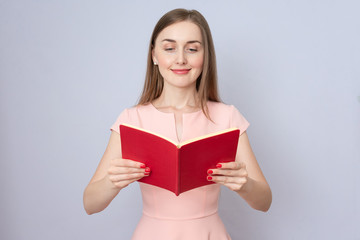 Attractive woman reads red book, portrait, copy space