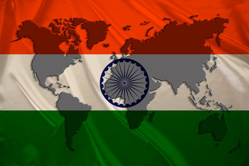 silhouette of a world map on the silk national flag of the modern state of india with beautiful folds, concept of tourism, travel, emigration, global business