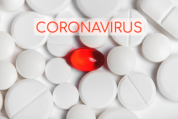 One red pill among white pills with coronavirus text.
