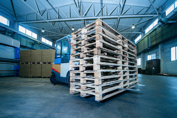 Worker driver of a forklift loader at warehouse of sandwich panels