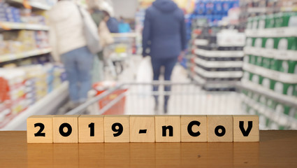 coronavirus covid-19 and blurred shop in background. Wooden blocks with inscription 2019-nCov. Concept of coronavirus quarantine.