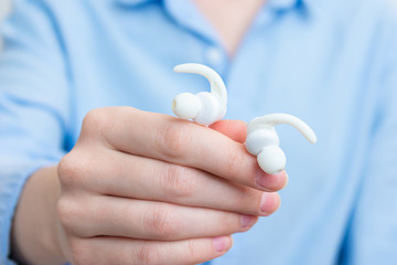 Woman with white headphones, women's hands, close up