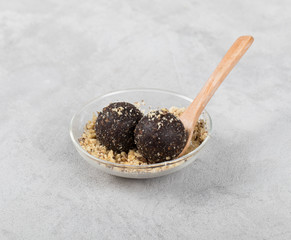 Vegan energy candies balls from dried prunes, dates, dried apricots and almonds, cashews, walnuts in a bowl on a light background