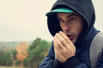 Traveler man warmly dressed on a autumn seasonal day, guy froze, portrait, closeup