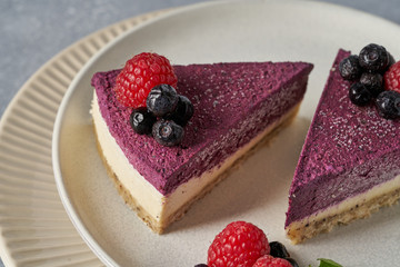 raw vegan double-layer cake with black currant on a light gray background under a concrete texture. Healthy eating, delicious dessert without baking
