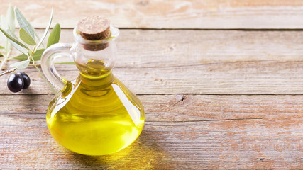 Healthy fats. Bottle of glass full of Extra Virgin Olive Oil made in Puglia, Salento on a wooden...