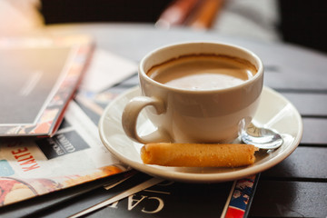A cup of americano coffee with cookies on a wooden table 