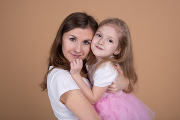 nother and her charming little daughter are hugging and smiling