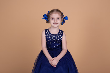 happy smiling little girl isolated on beige neutral background