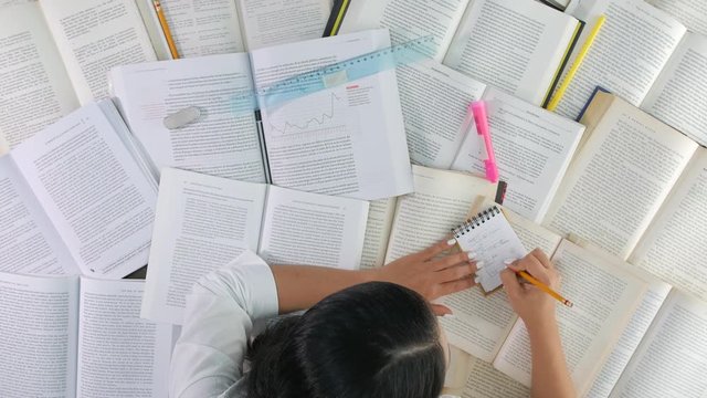 Funny timelapse of woman studying at desk with many books, top view