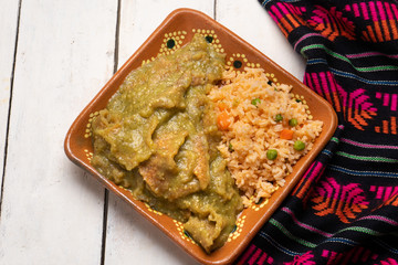 Mexican pork chicharron with green sauce and rice on white background