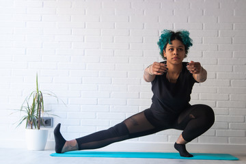 young woman doing gymnastics or sport at home or apartment