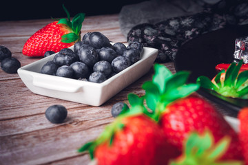 Still life of strawberry and blueberries. Dark food. Sweet dessert.