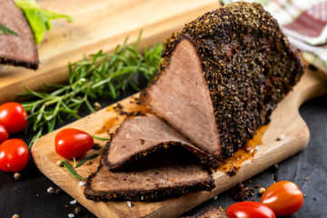 beef roasted in fresh herbs surrounded by baked vegetablesbee