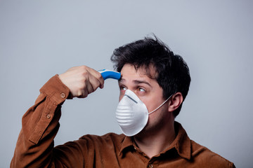 guy in the mask measures his temperature