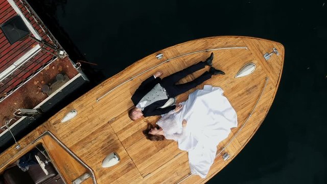 moving the camera up Aerial shot of young stylish couple lay on a boat in Europe Hallstatt. vacation honeymoon, luxury expensive vacation