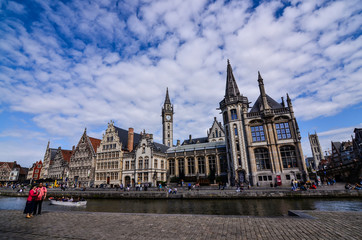 Fototapeta premium Ghent, Belgium, August 2019. Breathtaking cityscape: from the St. Michael bridge along the Graslei canal. One of the most beautiful postcards in the city. On the left a couple stopped to admire.