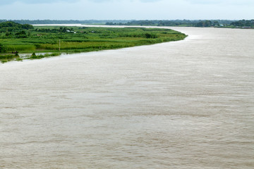 Monsoon, flooded river surrounded by green fields in rural Bangladesh