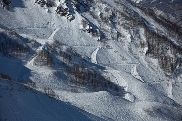 The slope for skiing. Slope for descent on a snowboard. Snow slope in the mountains. Traces of a snowboard on a hill. Top view of the track for the descent. A place to relax and ride.