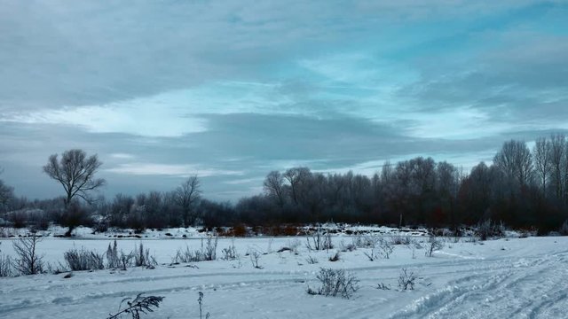 Panorama Evening Winter Landscape. Moving Along Rural Road in Plains. Cloudy Sky Above Snow Covered Field And River. Cold Weather on Winter Holidays