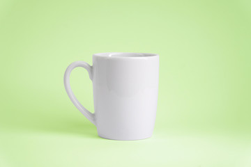 Weiße Tasse auf grünem Hintergrund. Platz für dein Logo oder Text.