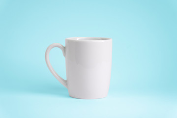 Weiße Tasse auf blauem Hintergrund. Platz für dein Logo oder Text.