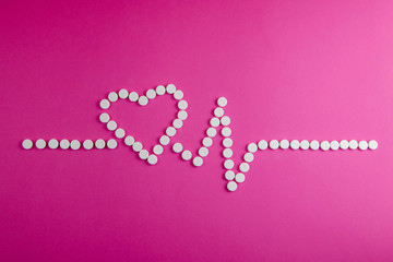 Medicine, healthcare and pharmacy concept - pills and of drugs in shape of the heart and heart...