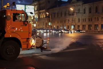Harvester watering the street with water. Wash the city road.