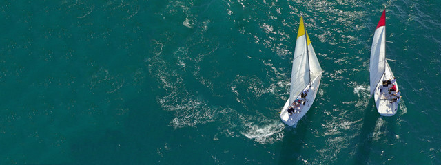 Aerial drone ultra wide photo of sail boats competing in annual regatta race in Saronic gulf, Greece