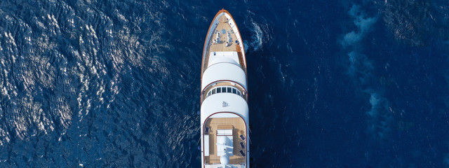 Aerial drone ultra wide top down photo of luxury yacht with wooden deck docked in Aegean island with deep blue sea, Greece - Powered by Adobe