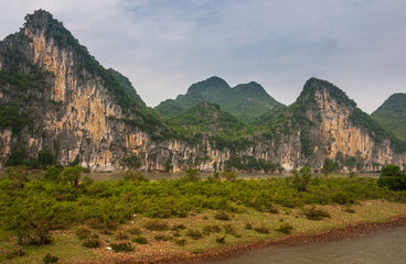 Guilin, China - May 10, 2010: Along Li River. Landscape with green forested karst mountains with...