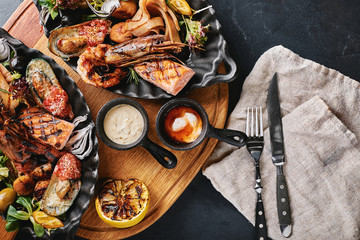 grilled seafood platter. Assorted delicious grilled seafood with vegetables. Grilled mixed bastards with pepper sauce and vegetables. Blue background