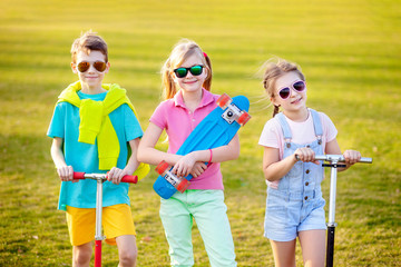 Fototapeta premium Sports kids with a skateboard in the park in spring. Outdoor sports.