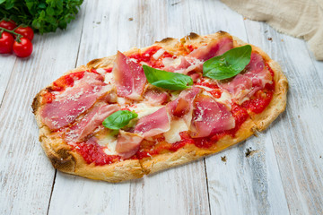 Pinsa with parma ham rome pizza on white wooden board