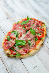 Pinsa with parma ham rome pizza on white wooden board