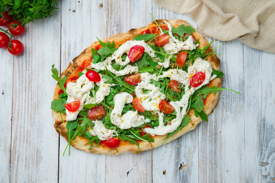 Pinsa with tomatoes, aragula and stracciatella. rome pizza