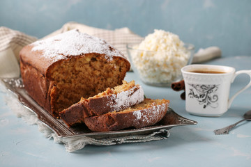 Homemade curd muffin on a metal tray and cup of coffee on a light blue background
