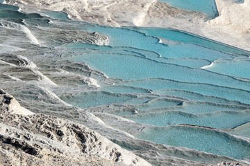 Looking down white Pamukkale travertines full of aquamarine water, Turkey
