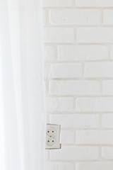 White brick wall and electrical outlet in Europe