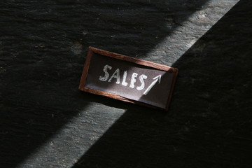 sales tag and piles of gold coins on a vintage table