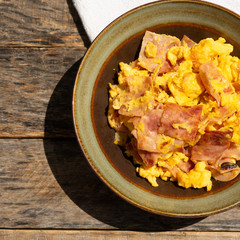 Eggs with ham for breakfast on wooden background