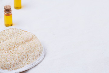 A luffah massage sponge on a beige organic cotton fabric