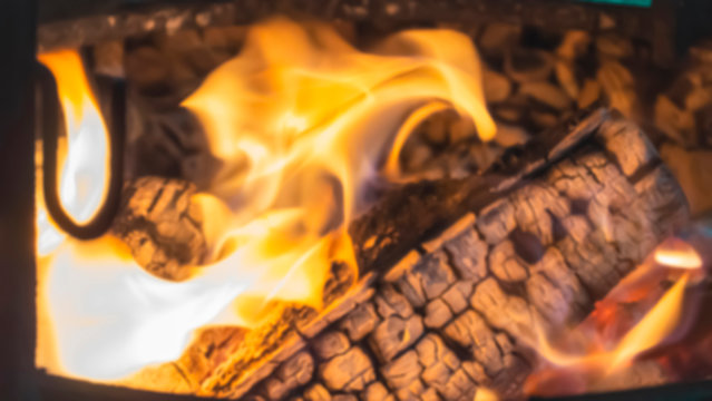 Burning Fire.Closeup. Bonfire, burning trees logs. Warm, cozy burning fire in a brick fireplace. Red, orange fire flame and smoke.Template.Place for text.