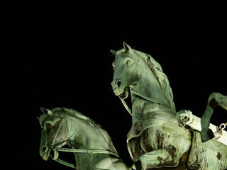 Part of the statue of the Goddess Victoria on Brandenburg gate at night. Brandenburg Tor. Famous landmark. On black background, Close up. © Kost9