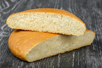 Round flat yeast bread made of wheat flour on a gray wooden background