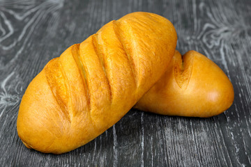 Bread white loaf of wheat flour with incisions on a gray wooden background